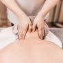 A massage therapist Springhouse executing a specific back massage treatment with hands applied to the upper back.