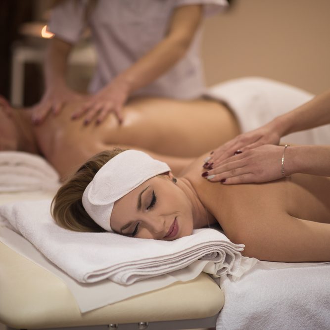 Couple receiving a Couples Massage Springhouse A woman and a man enjoy a relaxing couples massage in a comfortable massage environment.