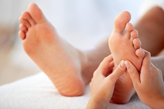 Foot Massage Treatment Hands applying pressure to a person's foot, possibly during a massage or therapy session.