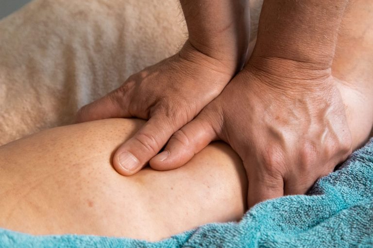 : This image depicts a therapeutic massage technique, such as deep-tissue or sports massage, intended to release muscle tension/reduce pain.